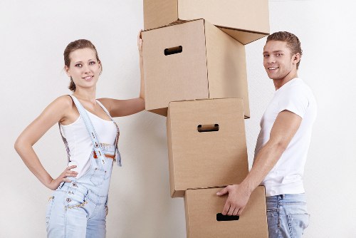 Professional movers handling desks, chairs, and IT equipment for a West Brompton office move
